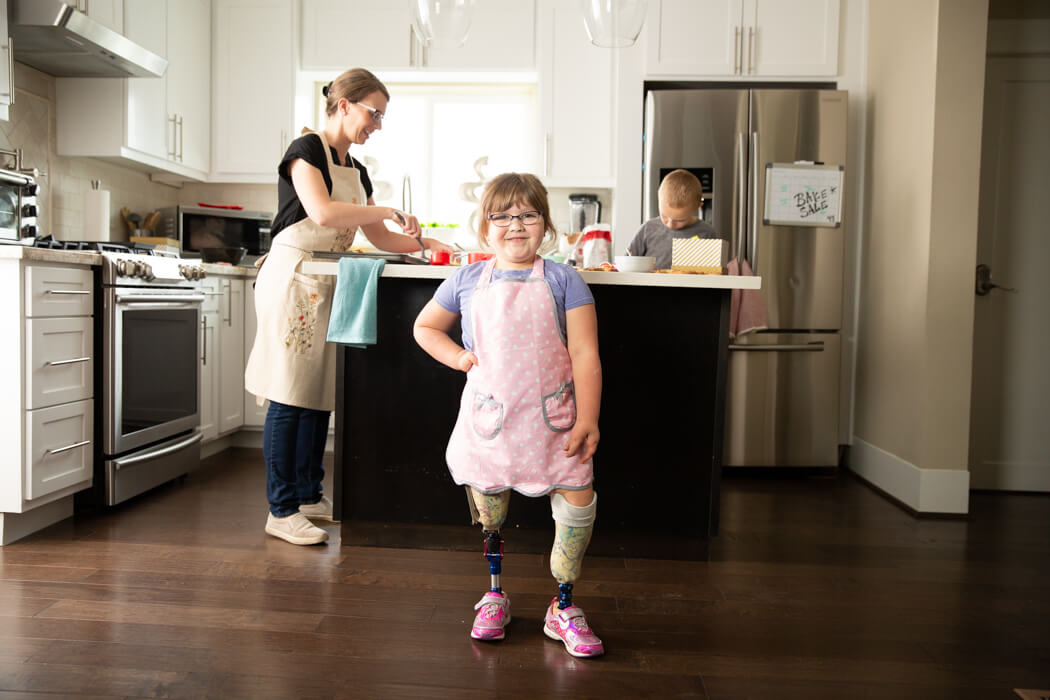 Riling showing off her new pink shoes while her mother bakes in the background.