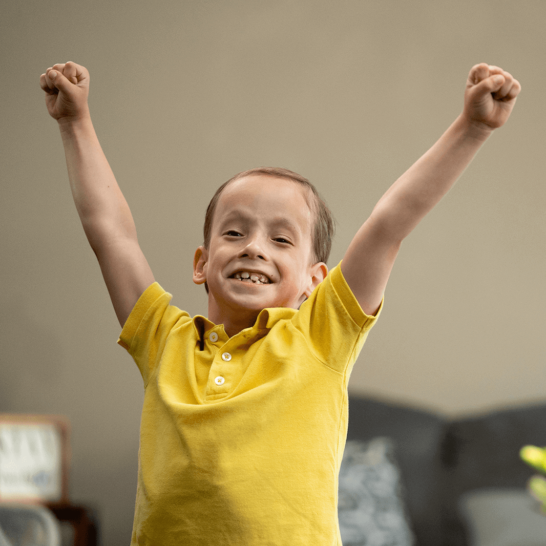 Young boy Shriners patient raises arms in cheer