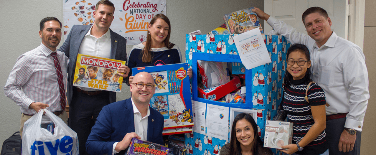 Corporate sponsor Exploria group poses with donated Christmas gifts