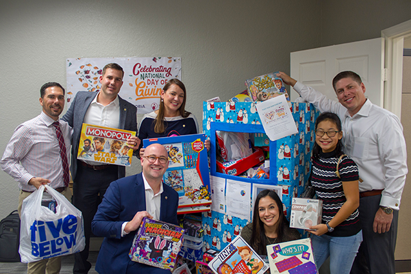 Corporate sponsor Exploria group poses with donated Christmas gifts
