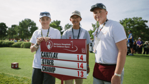 Three young male patients holding golf scorecard at Shriner Open