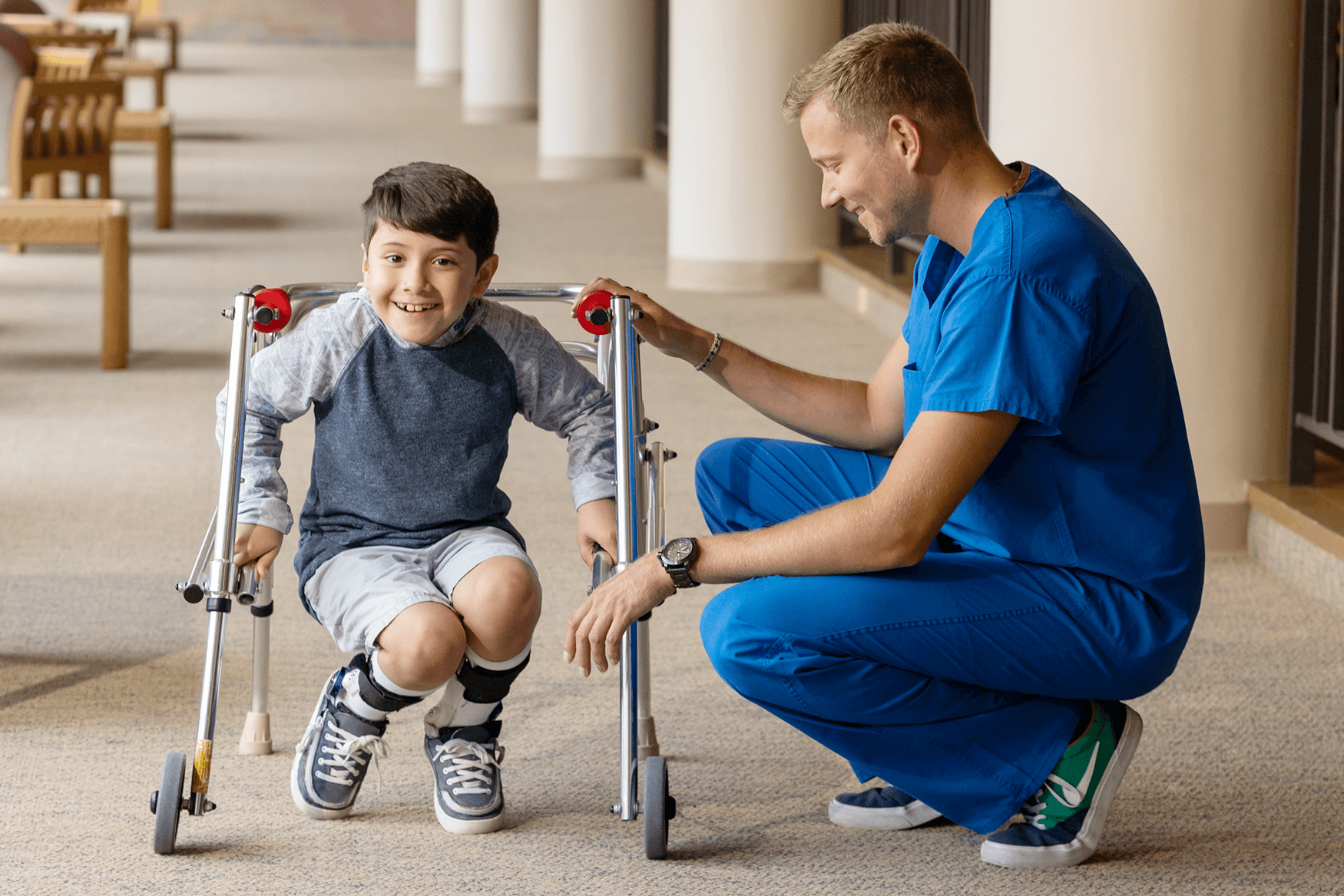 Boy Shriners patient smiles alongside male doctor
